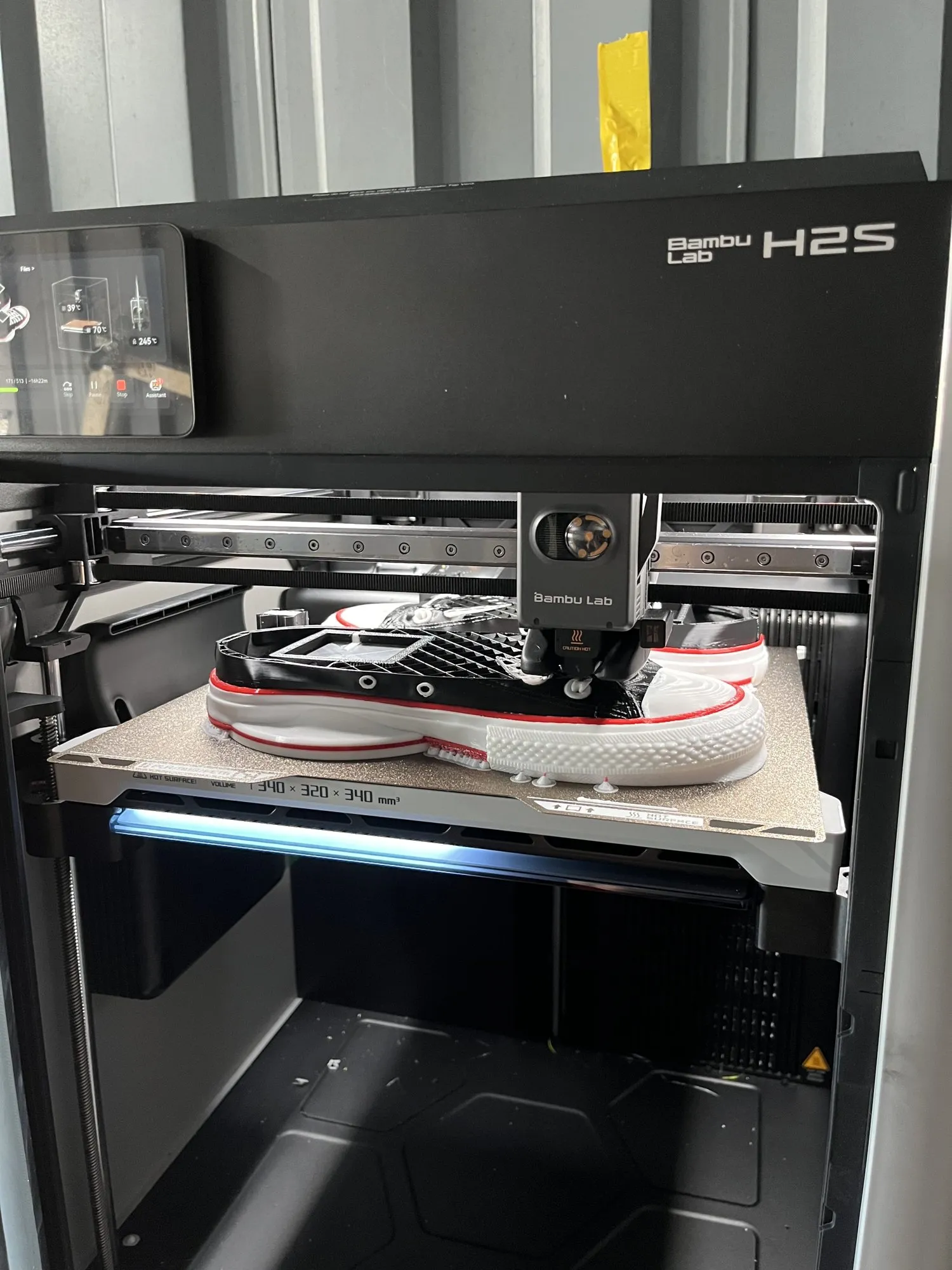 A pair of multicolor sneakers partway through printing on the build plate of a Bambu Lab H2S
